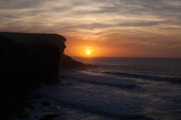An amazing shot of a beautiful coastal cliff on a seaside sunset background - Zdjęcie, obraz