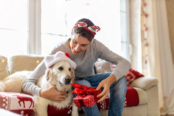 Tinédzser fiú és a kutyája együtt karácsonyoznak otthon  - Fotó, kép