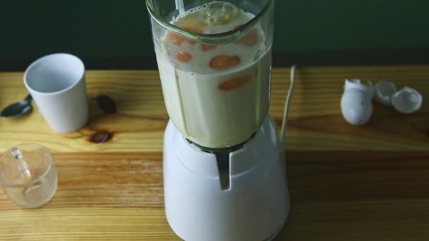 pohled shora na skleněný kalich na elektrický mixér s kondenzovaným mlékem a vejci - Záběry, video