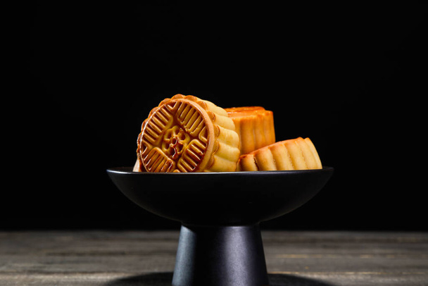 A closeup shot of mooncakes on a black bowl - Foto, imagen