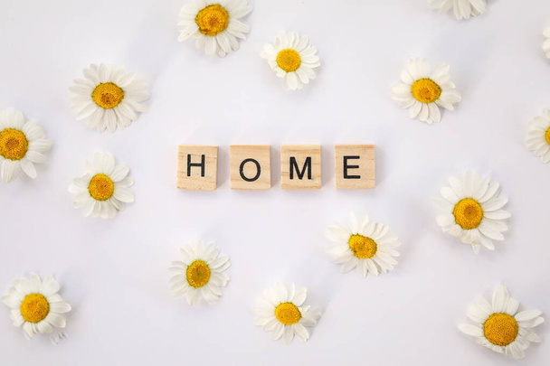 The word "Home" isolated on a white background surrounded by little Chamomile flowers - Foto, Bild