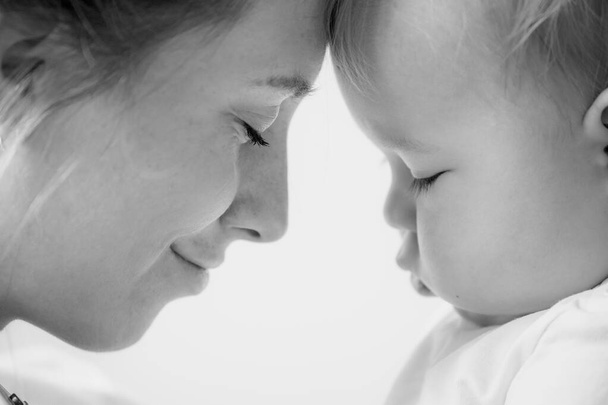 portrait of mother with her son, profile, black and white, soft focus, happy motherhood and childhood concept - Valokuva, kuva