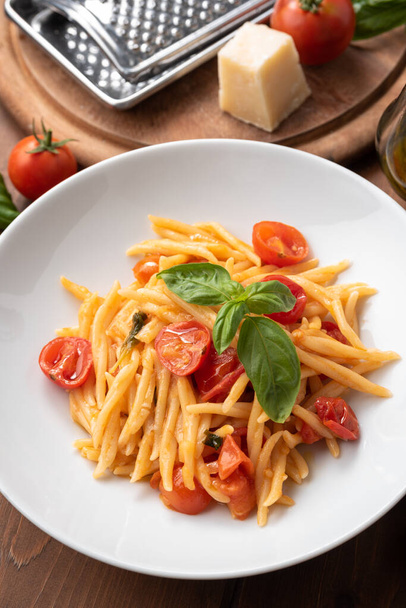 Plaat van heerlijke trofie pasta met basilicum en kerstomaten, Italiaans eten  - Foto, afbeelding