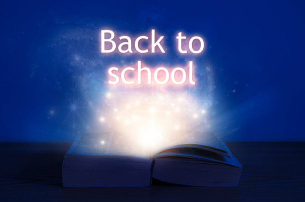 Livre ouvert avec inscription de retour à l'école. Lumière provenant du livre ouvert avec des mots de retour à l'école. - Photo, image