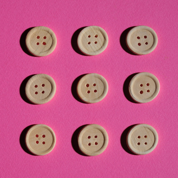 Concept of nine wooden buttons on a pink background ... - Fotografie, Obrázek