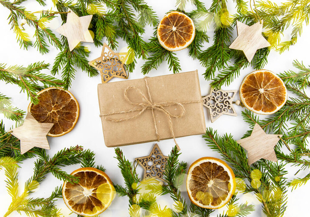 Gift in a craft box with eco decor, spruce branches and dried orange around. - Foto, Imagen