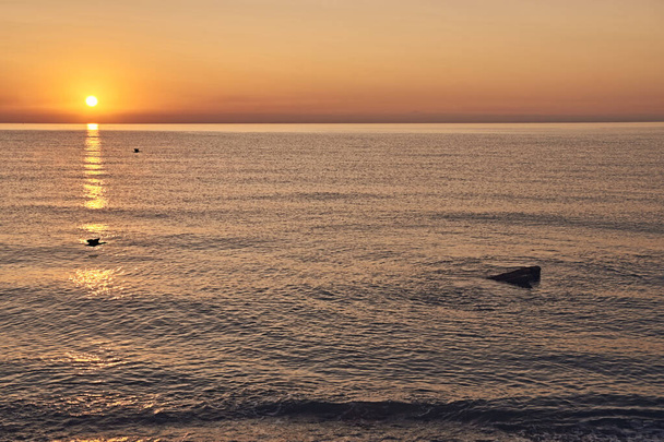 Kumsalda gün doğumu, kayalarda güneş, çizgiler, portakallar - Fotoğraf, Görsel