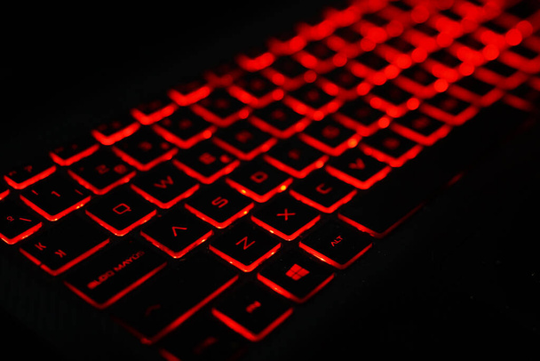 A closeup of a keyboard with a red backlight on isolated background - Foto, Bild