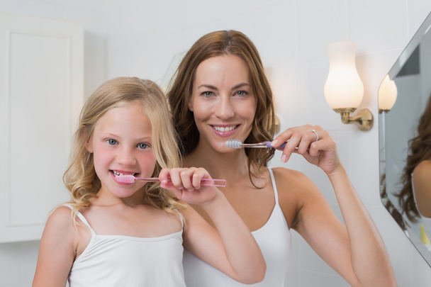 Portrait up of mother and daughter brushing teeth - Photo, image