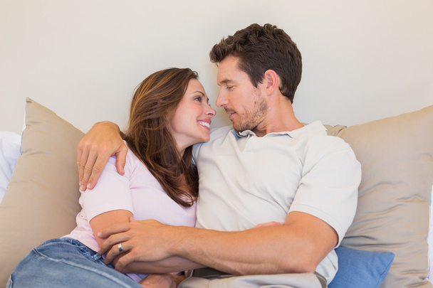 Loving couple sitting on couch at home - Foto, Bild
