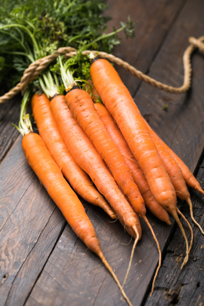 Fresh carrots bunch on rustic background. Healthy vegan vegetable food. - 写真・画像