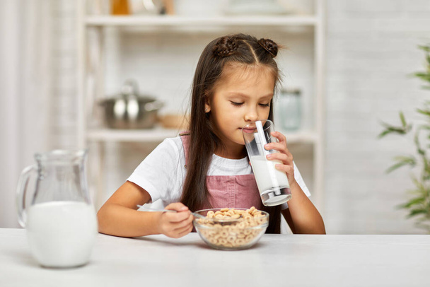 cute little girl eating breakfast: cereal with the milk - Fotografie, Obrázek