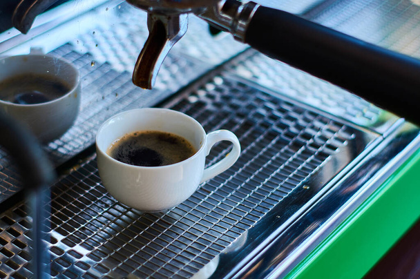 The process of making coffee in white ceramic cup on professional coffee machine. - Фото, зображення