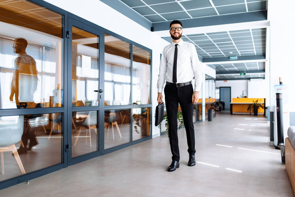 Успешный бизнесмен, идущий по коридору офиса - Фото, изображение