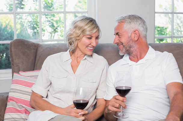 Happy relaxed mature couple with wine glasses in living room - Photo, Image