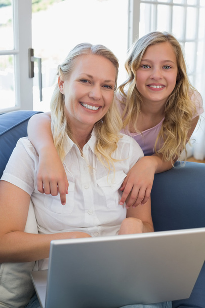 Girl pointing at laptop while mother using it - Foto, immagini