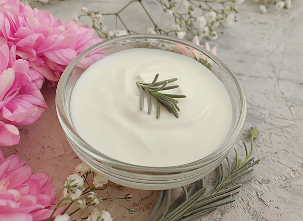cosmetische crème, bloem op een betonnen achtergrond - Foto, afbeelding