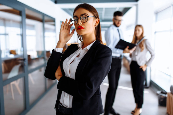 Business young woman, group of people in the background in modern office indoors - Foto, Imagem