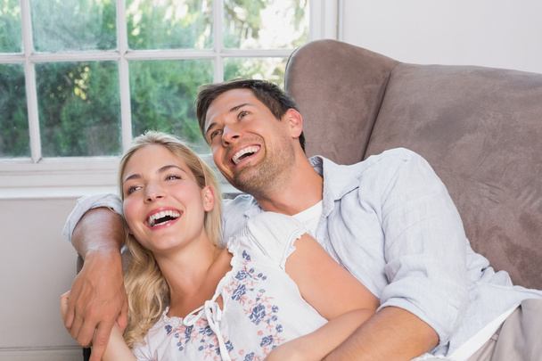 Повседневная молодая пара смеется в гостиной
 - Фото, изображение