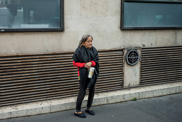 PARIS, FRANCJA - 7 października 2016: Bezdomna kobieta błaga o pieniądze w centrum Paryża we Francji - Zdjęcie, obraz