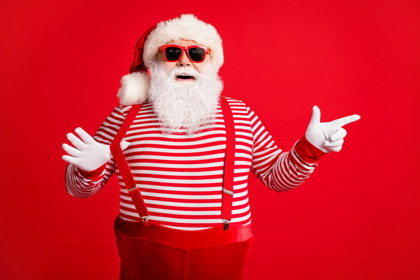 Portrait of his he nice handsome attractive cheerful funny positive bearded fat gray-haired Santa showing copy space December bargain isolated on bright vivid shine vibrant red color background - Foto, Bild