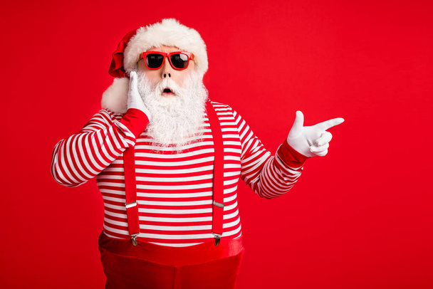 Portrait of his he nice handsome attractive wondered amazed bearded fat gray-haired Santa demonstrating copy space novelty look idea isolated on bright vivid shine vibrant red color background - Photo, image