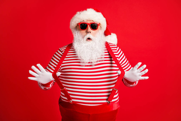 Portrait of his he nice handsome attractive comic childish amazed grey-haired Santa having fun pulling suspenders festal look outfit isolated over bright vivid shine vibrant red color background - Photo, Image