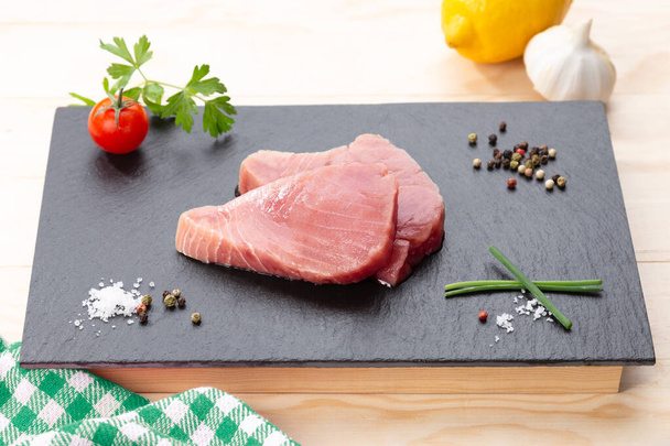 Fresh raw tuna steaks with seasoning . - Foto, afbeelding