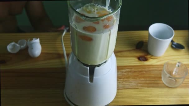 вид сверху на электрическую чашу из блендера со сгущенным молоком и яйцами - Кадры, видео