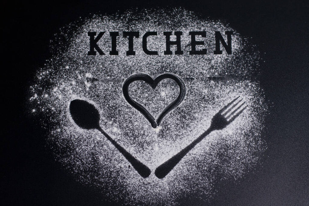 Images of forks and spoons on a white flour background. Lettering-kitchen and drawing a heart on top. - Valokuva, kuva