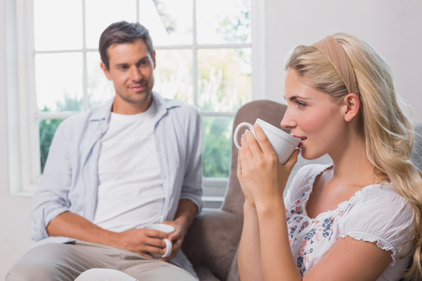 Relaxed couple with coffee cups sitting in living room - Photo, Image