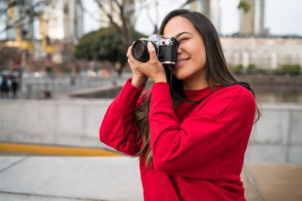 Young woman using a professional camera. - Foto, afbeelding