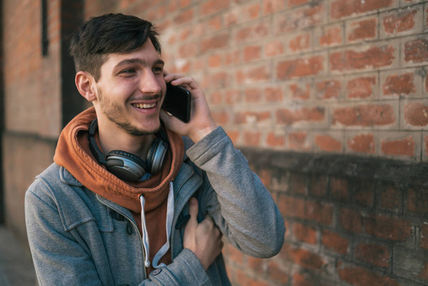Jeune homme parlant au téléphone à l'extérieur. - Photo, image