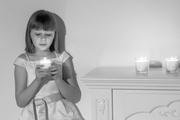 A little girl in a dark room by candlelight. - Valokuva, kuva
