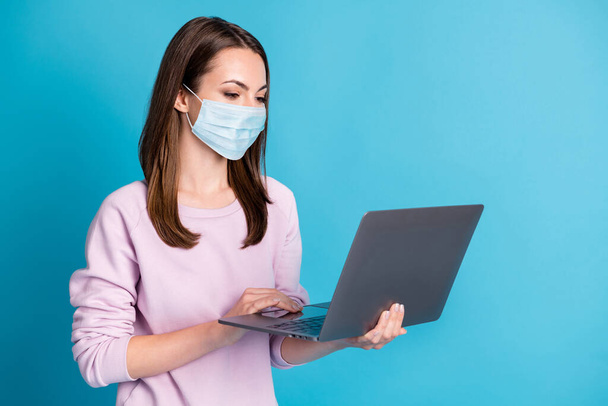 Photo of attractive student lady hold notebook hands wear blue face mask isolated blue color background - Φωτογραφία, εικόνα