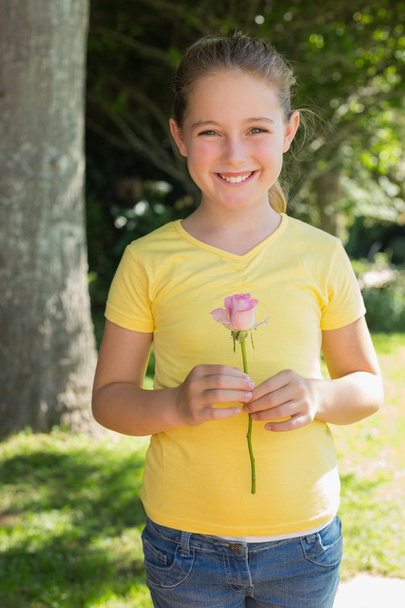 Girl holding flower in park - Φωτογραφία, εικόνα