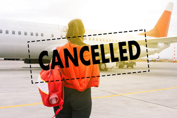 Cancelación de vuelos por coronavirus. Una joven viajera se para cerca del avión. Vacaciones turísticas canceladas. - Foto, Imagen