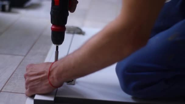 proces remontu mieszkania. fettler wierci gwoździe elektrycznym śrubokrętem w zawiasy drzwiowe na elewacji. nierozpoznawalnych mężczyzn. remonty, remonty. Nagrania w Full HD - Materiał filmowy, wideo