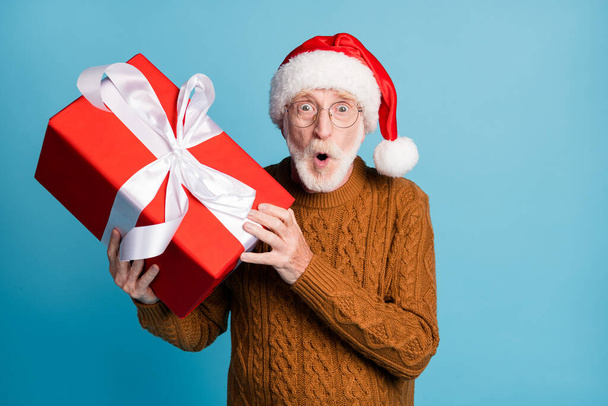Portrait of his he nice attractive cheery amazed stunned elderly bearded grey-haired Santa father holding in hands big large giftbox pout lips wow sale isolated on blue pastel color background - Foto, Imagem