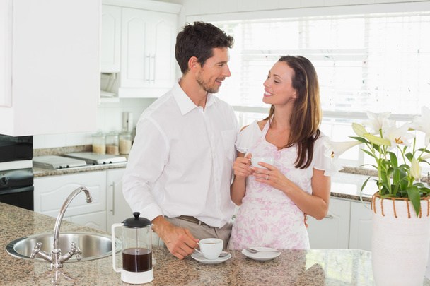 Happy young couple having coffee in kitchen - Fotografie, Obrázek