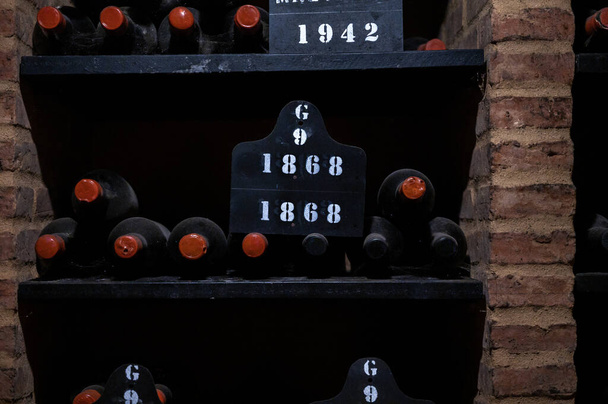 Бутылки винтажного укрепленного рубинового или тауни-порто вина в старых подвалах Вила-Нова-де-Гайя, Португалия, на севере Португалии - Фото, изображение