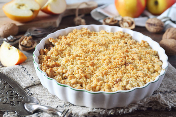 Apple crumble with walnuts on wooden background, rustic style - Photo, Image