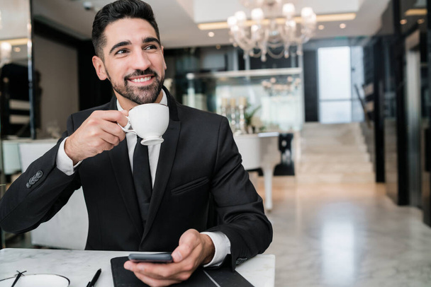 Businessman drinking coffee at hotel lobby. - Foto, Imagem