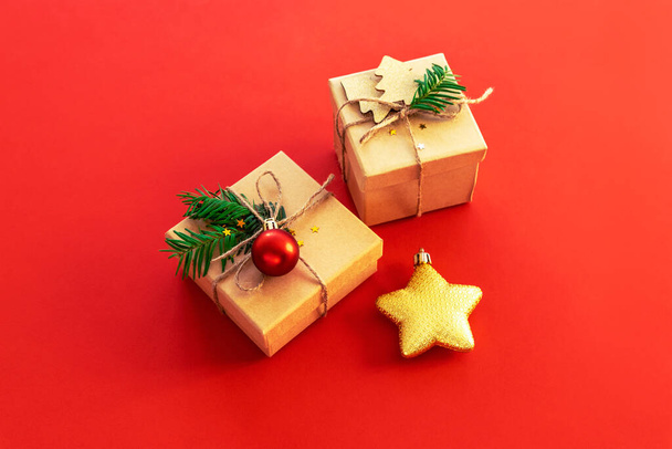 Two gifts in boxes and Christmas toy star on red background, top view. New Year concept. - Photo, Image