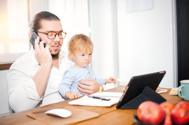 Young dad with a child working at home - Foto, Bild