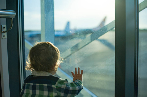 Chico mira por la ventana en el aeropuerto - Foto, imagen