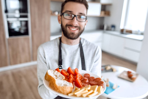 plate of sandwiches in the hands of an attractive man - Fotoğraf, Görsel