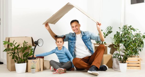 Familie packt Pappkartons im neuen Zuhause aus - Foto, Bild