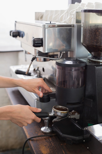 Mid section of a barista prepares espresso in coffee shop - Foto, Bild