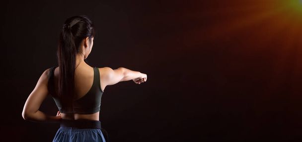 Ulusal sporcu olan Kara Kemer Tekvando Karate Kız geleneksel dövüş pozlarını spor elbisesi, siyah arka planda izole edilmiş fotokopi alanı ve arka planda gösteriyor. - Fotoğraf, Görsel